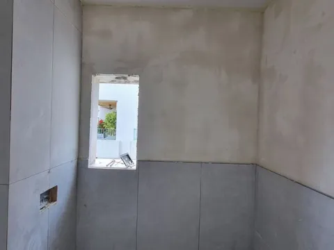 קירות מטויחים לפני התקנת חיפוי במקלחת האורחים