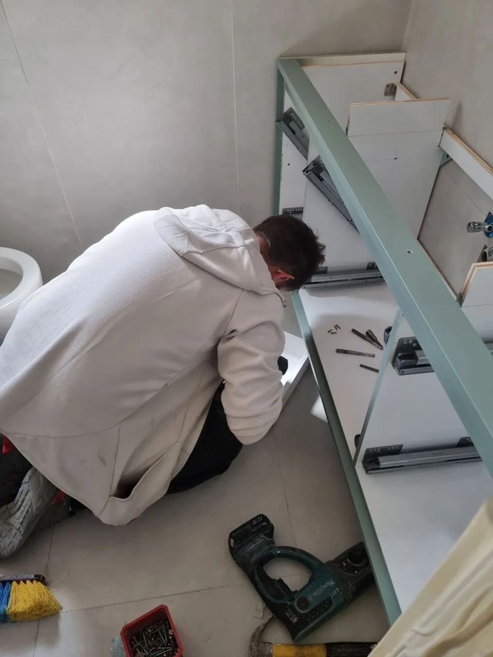 התקנת ארון הכיור בזמן עבודות השיפוץ בחדר המקלחת