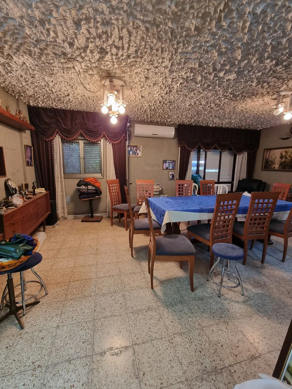 פינת אוכל ישנה עם תקרת טיח מעוצבת ווילונות כהים לפני השיפוץ