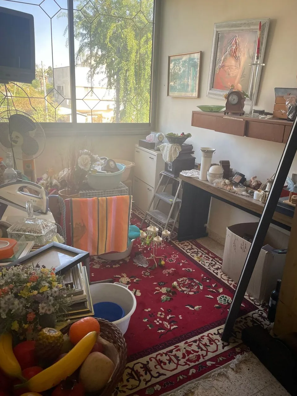 חדר אחסון עמוס בחפצים ורהיטים ישנים לפני השיפוץ