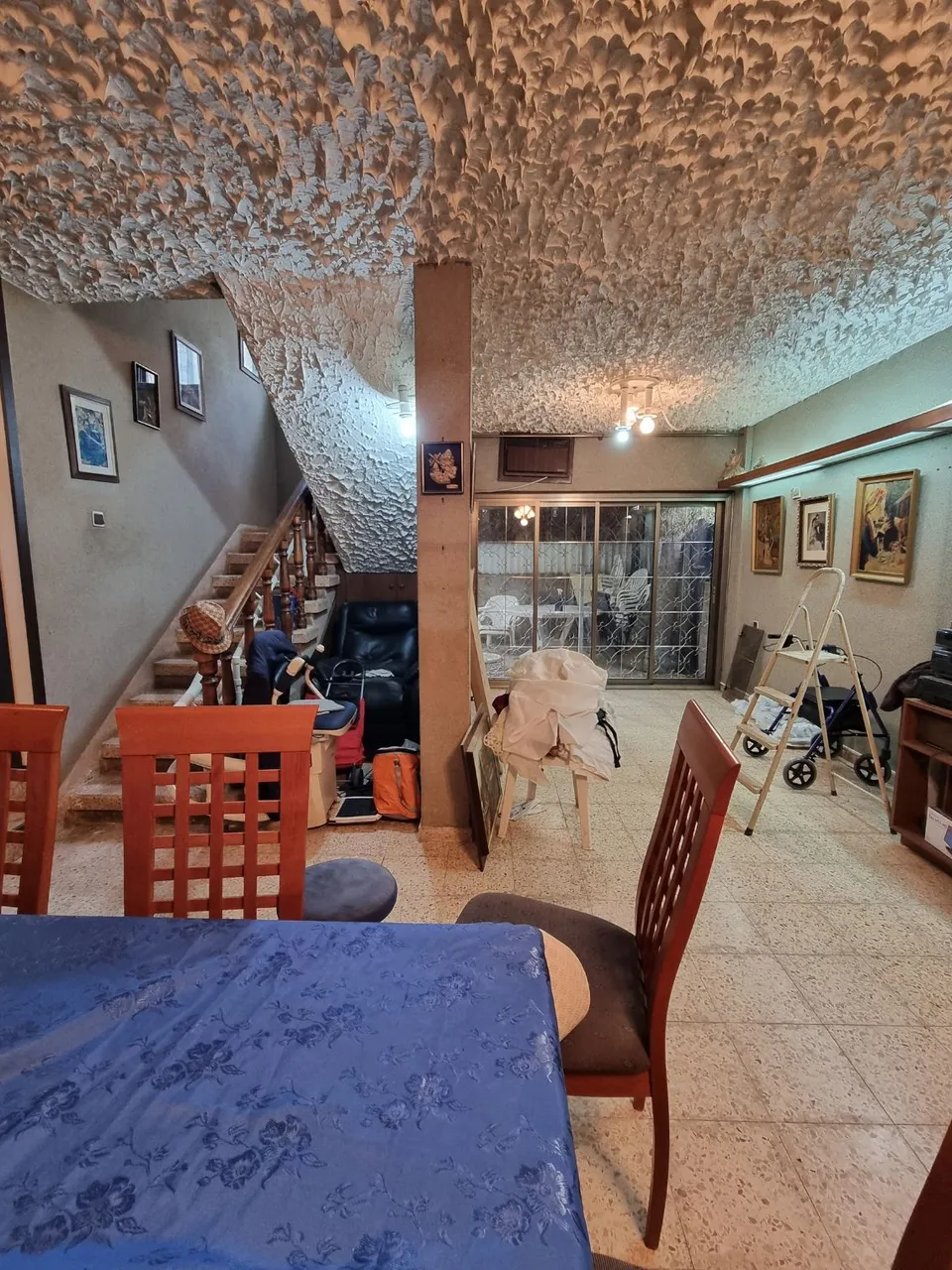 פינת ישיבה ישנה ליד המדרגות עם הליכון רפואי לפני השיפוץ